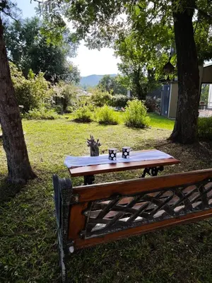 a picnic table with four coffee cups on it next to a bench at Casa Manantiales in Villa General Belgrano