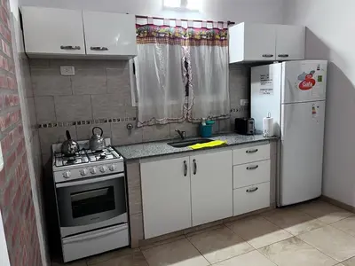 a kitchen with a stove and a refrigerator at Cabañas Paz in Carpintería