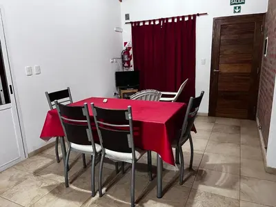 a dining room with a red table and chairs at Cabañas Paz in Carpintería