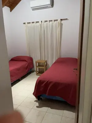 a bedroom with two beds and a red blanket at Cabañas Paz in Carpintería
