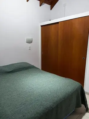 a bedroom with a bed and a wooden closet at Cabañas Paz in Carpintería