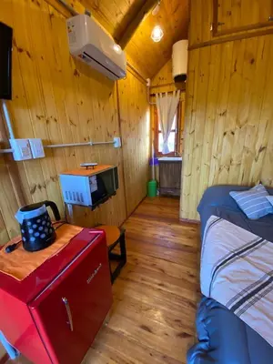 a room with two beds and a television in a cabin at CUYEN LA SERRANITA Dormi DLX Cabin para 2 Personas in Villa Serranita