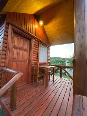 a cabin with a wooden deck with a table and a door at CUYEN LA SERRANITA Dormi DLX Cabin para 2 Personas in Villa Serranita