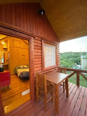 a wooden cabin with a table and a bed at CUYEN LA SERRANITA Dormi DLX Cabin para 2 Personas in Villa Serranita