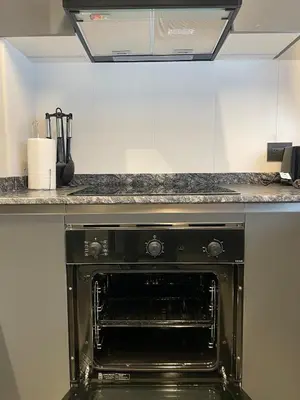 a black oven in a kitchen with a counter at Faz Flat in Cordoba