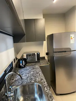 a kitchen with a sink and a refrigerator at Faz Flat in Cordoba
