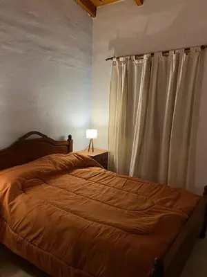 a bedroom with a bed and a white curtain at Cabaña Don Licho in San Javier