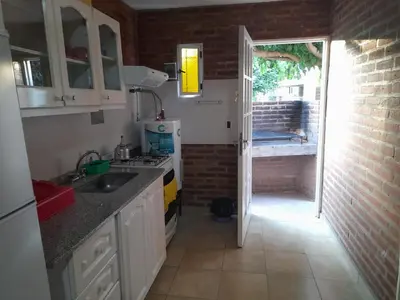a kitchen with a sink and an open door at Cabañassoleado Villa Cura Brochero in Villa Cura Brochero
