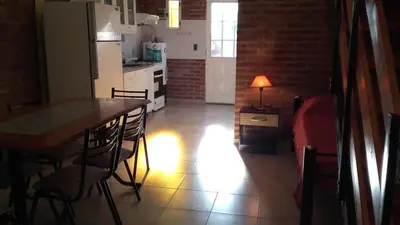 a kitchen and dining room with a table and chairs at Cabañassoleado Villa Cura Brochero in Villa Cura Brochero