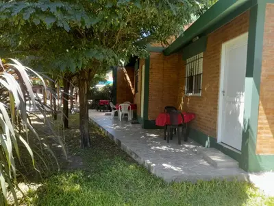 a house with a table and chairs on the side of it at Cabañassoleado Villa Cura Brochero in Villa Cura Brochero