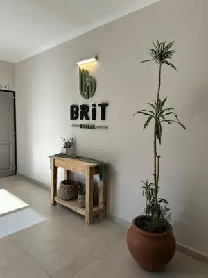 a plant in a room with a table and a sign at Brit Hotel in Villa Carlos Paz
