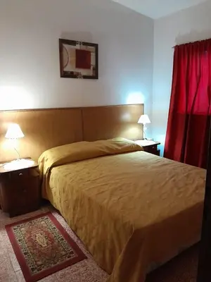 a bedroom with a bed and a red curtain at La Morada de sus Sueños in Bialet Massé