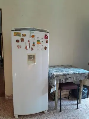 a white refrigerator in a room with a table at La Morada de sus Sueños in Bialet Massé