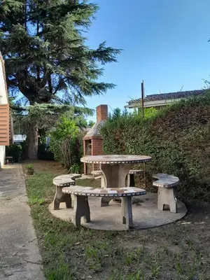 a picnic table and benches in a park at La Morada de sus Sueños in Bialet Massé