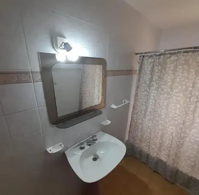 a bathroom with a white sink and a mirror at Departamento céntrico Villa Carlos Paz in Villa Carlos Paz