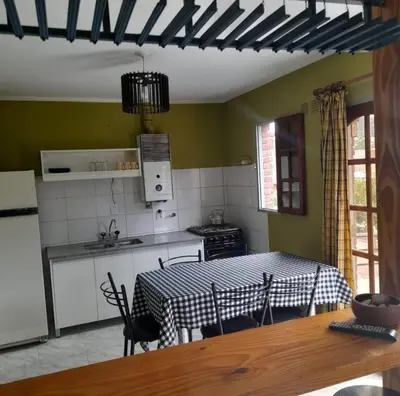 a kitchen with a table and a kitchen with a table and chairs at Departamento céntrico Villa Carlos Paz in Villa Carlos Paz