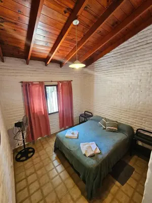 a bedroom with a bed and a wooden ceiling at Casa Tilo número 1 in Mina Clavero