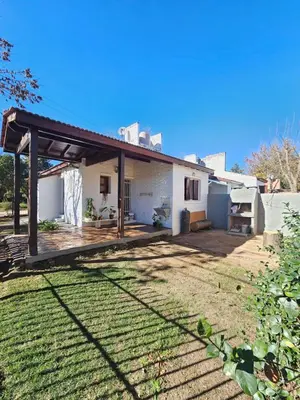 a house with a wooden deck in the yard at Casa Tilo número 1 in Mina Clavero