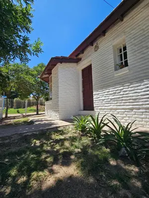 a white building with a door and some plants at Casa Tilo número 1 in Mina Clavero