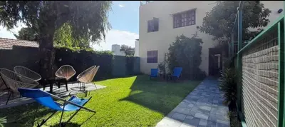 a yard with chairs and a house at Departamento centrico Villa Carlos Paz in Villa Carlos Paz