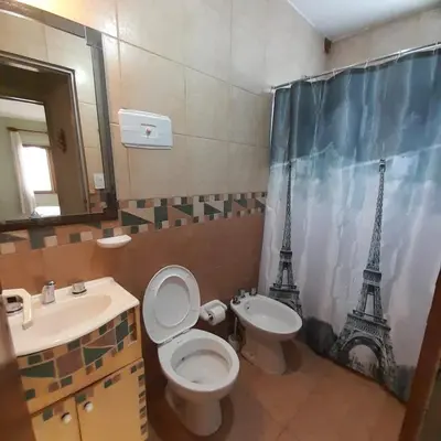 a bathroom with a toilet and a sink and the eiffel tower at Departamento centrico Villa Carlos Paz in Villa Carlos Paz