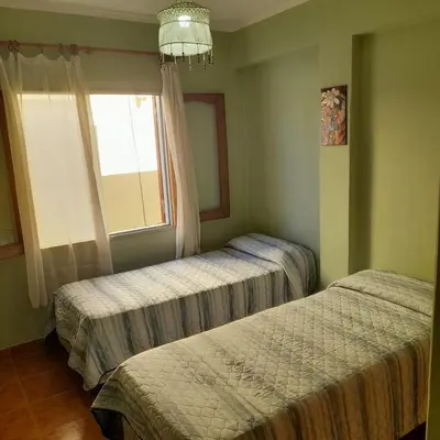 two beds in a bedroom with a window at Departamento centrico Villa Carlos Paz in Villa Carlos Paz