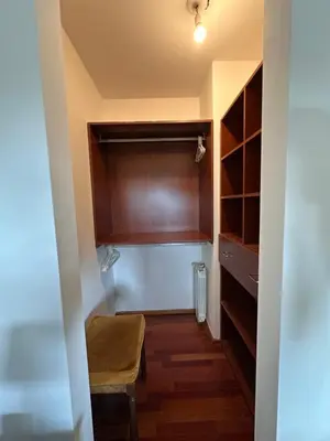 a hallway with a closet with a bench and a chair at Departamento Complejo Privado Mai Tei in Cordoba