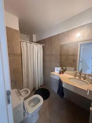 a bathroom with a toilet and a sink at Departamento Complejo Privado Mai Tei in Cordoba