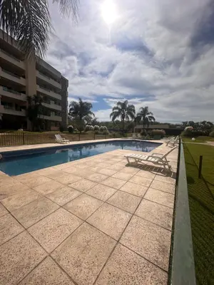 a swimming pool with chairs and a building at Departamento Complejo Privado Mai Tei in Cordoba