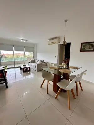 a living room with a table and chairs and a couch at Departamento Complejo Privado Mai Tei in Cordoba