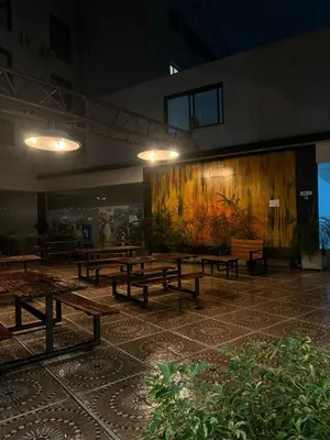 a group of benches in a building with a painting on the wall at Hotel Golden Ross in Villa Carlos Paz
