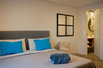 a bedroom with a large bed with blue pillows at Moderno loft en Güemes in Cordoba