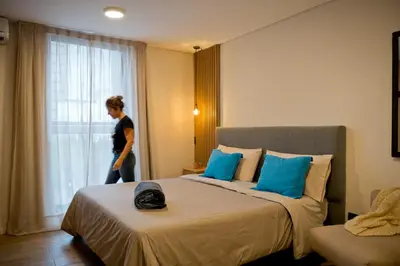 a woman standing in a hotel room looking out the window at Moderno loft en Güemes in Cordoba