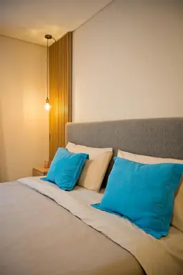 a bed with two blue pillows on top of it at Moderno loft en Güemes in Cordoba