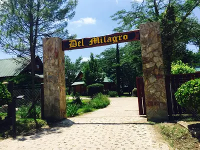 a gate to a garden with a sign that reads el albuquerque at Del Milagro Cabañas & Posada in Villa General Belgrano