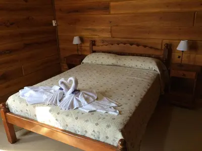 a bedroom with a bed with a dress on it at Del Milagro Cabañas & Posada in Villa General Belgrano