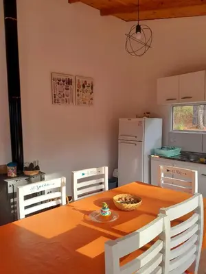 a kitchen with a table and chairs and a refrigerator at Luna Azul in Villa Yacanto