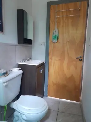 a bathroom with a toilet and a wooden door at Luna Azul in Villa Yacanto