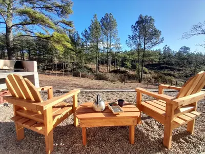 two wooden chairs sitting next to a table with a coffee table at Luna Azul in Villa Yacanto
