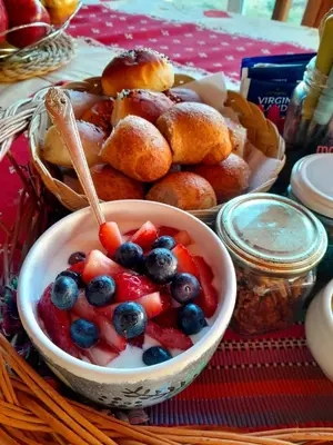 a bowl of fruit and blueberries and pastries on a table at Luna Azul in Villa Yacanto