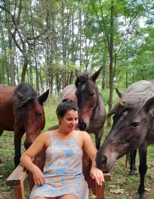 a woman sitting next to a group of horses at Luna Azul in Villa Yacanto