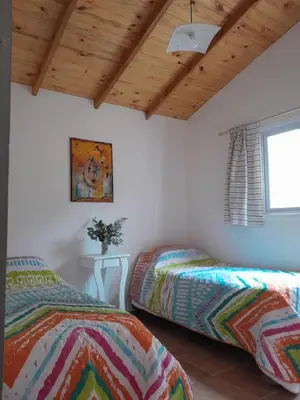 a bedroom with two beds and a wooden ceiling at Luna Azul in Villa Yacanto
