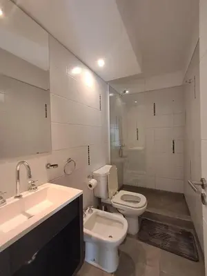 a white bathroom with a toilet and a sink at Figueroa Alcorta B Centro in Cordoba