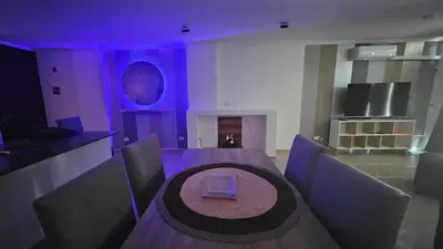 a dining room with a table and purple lighting at Duplex Luxor Calazans in Cordoba