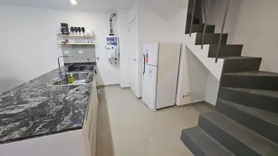 a kitchen with a sink and a counter with a staircase at Duplex Luxor Calazans in Cordoba