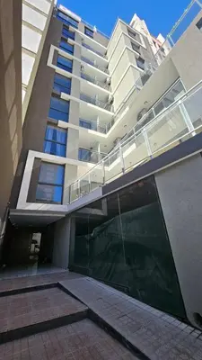a large building with a glass door in front of it at Duplex Luxor Calazans in Cordoba