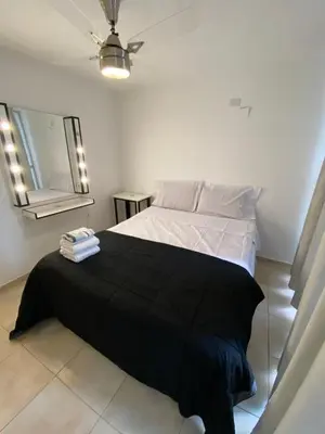 a bedroom with a bed with a black blanket on it at LitStay Trejo in Cordoba
