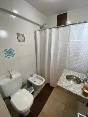 a white bathroom with a toilet and a sink at LitStay Trejo in Cordoba