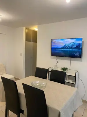 a dining room with a table and a tv on the wall at LitStay Trejo in Cordoba