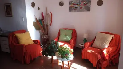 two red chairs and a table in a living room at Petunia in Cordoba